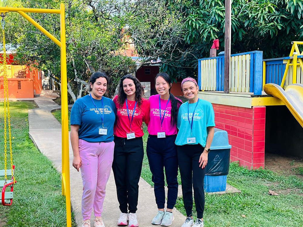 Four OT students pose for photo on playground