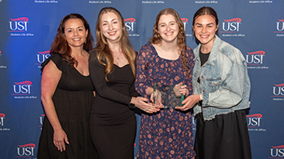 Members of student organization holding a trophy