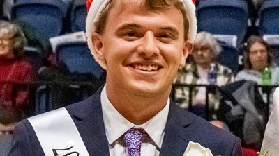 Photo of Homecoming King with crown and sash