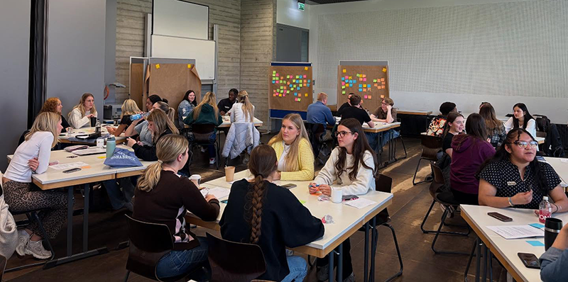 Students in group discussion in a large classroom in Germany