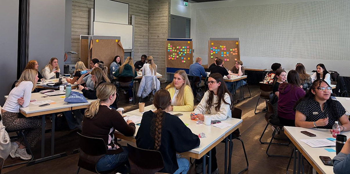 Students in group discussion in a large classroom in Germany