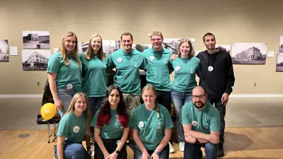 Group of American Chemical Society members in matching t-shirts posing for a photo in a museum gallery