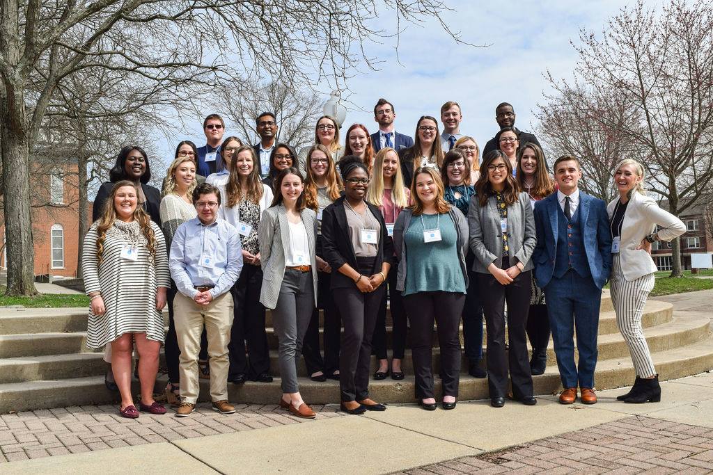 A large group of USI psychology students pose in professional attire with name badges