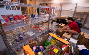 Student sorting food and putting it on shelves