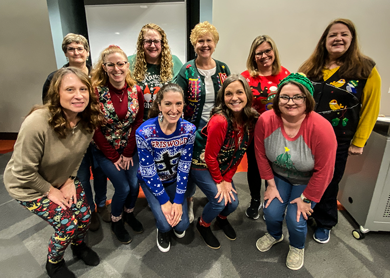 Group photo of Kinney College faculty and staff in holiday sweaters
