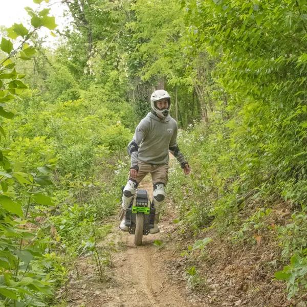 A student on his one wheel motorized scooter on the mountain bike trails. 