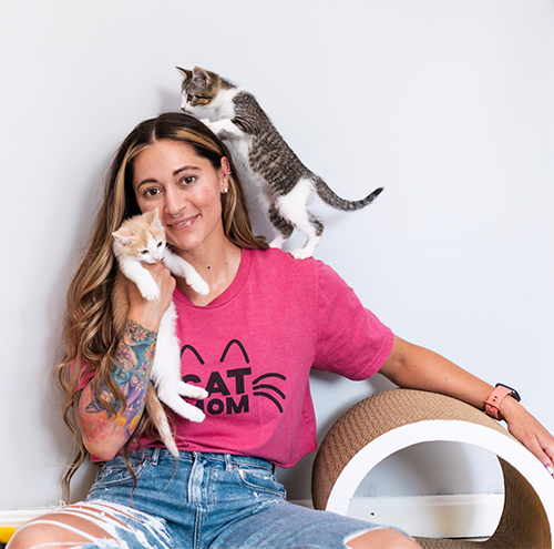 young woman with kittens climbing on her