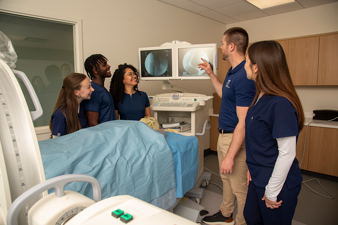 A group of students look at a radiology image on a screen in the simulation lab