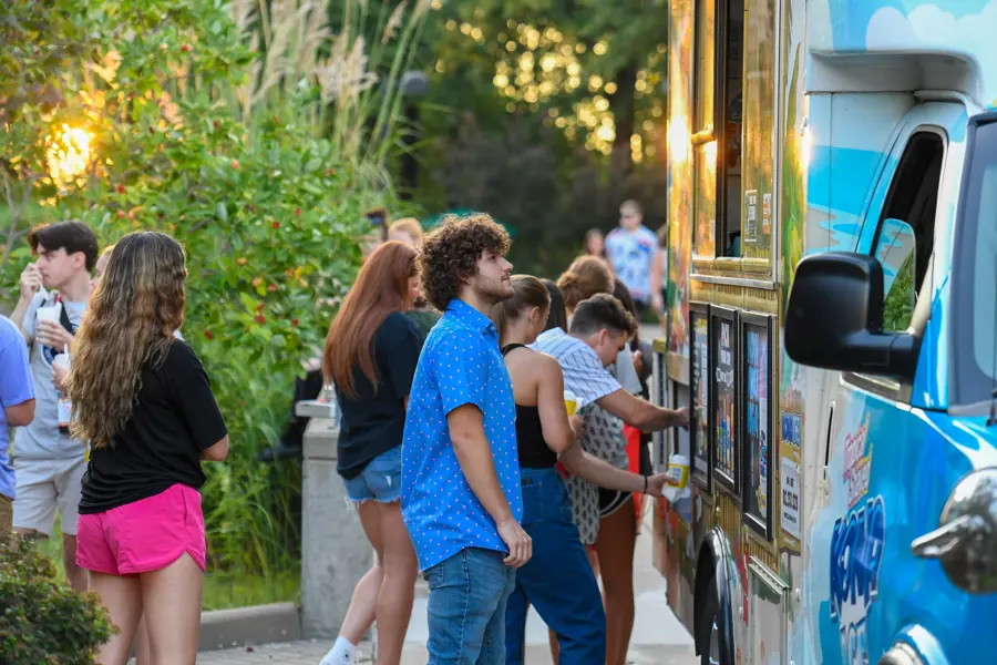 Students stand in line for a food truck at an on-campus event