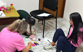 Students sitting on floor with child patient
