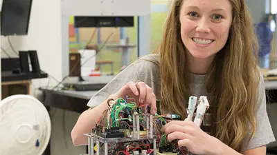 Engineering student smiles while working on a project