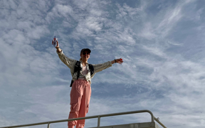 Faculty member on top of bus, arms spread, during safari in Mole National Park