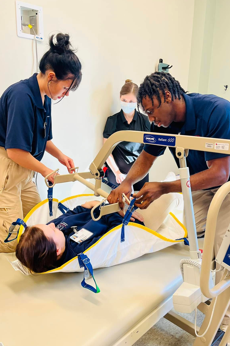 OTA students using a patient lift