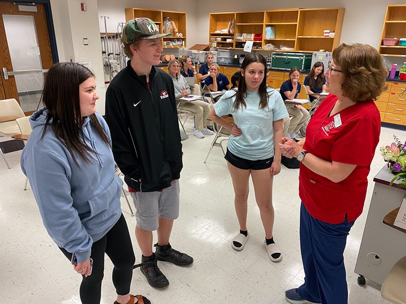 Student talking with teens who visited her class