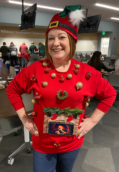 Staff member in elf hat and ugly sweater