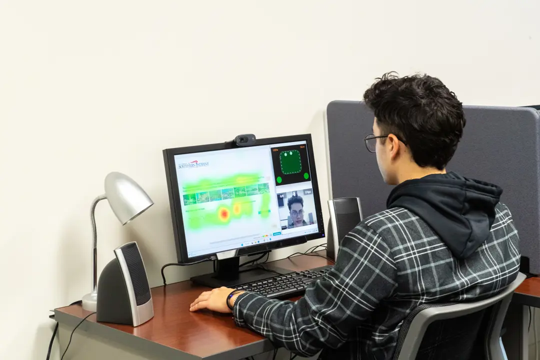 A student does facial analysis research in the Biometrix Discovery Lab