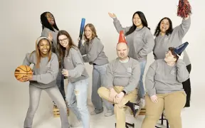 Area Coordinators play with athletic props and make silly in the photo studio for their informal group photo.